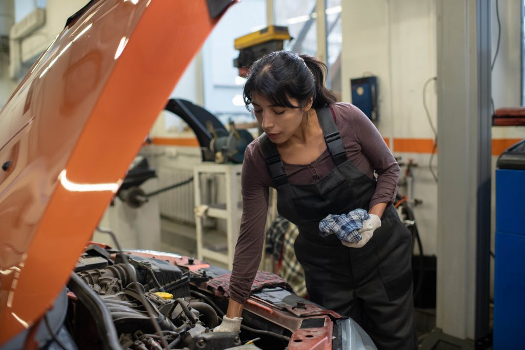 woman working on car maintenance